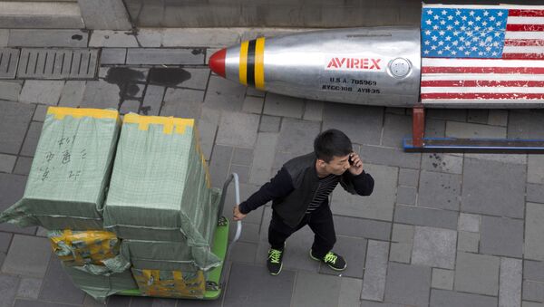 Китайский рабочий рядом с лавкой, раскрашенной в цвет американского флага - Sputnik Абхазия