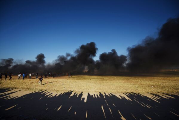 Палестинские протестующие во время столкновений с израильскими военными на границе сектора Газа и Израиля - Sputnik Абхазия