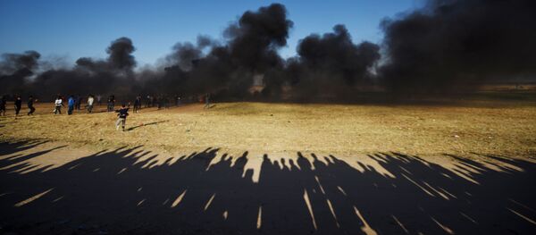 Палестинские протестующие во время столкновений с израильскими военными на границе сектора Газа и Израиля Палестинские протестующие во время столкновений с израильскими военными на границе сектора Газа и Израиля - Sputnik Абхазия