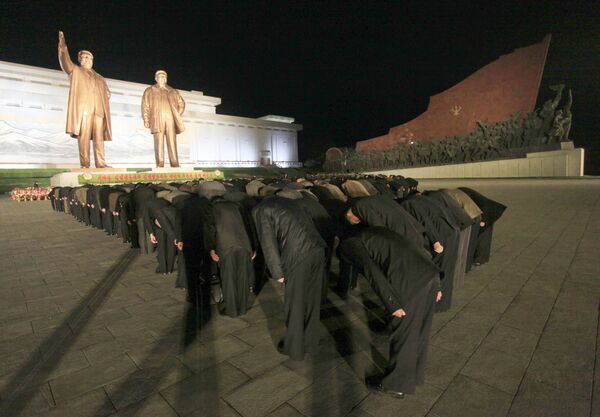Северокорейцы кланятся статуям лидеров КНДР Ким Ир Сена и Ким Чен Ира в Пхеньяне - Sputnik Абхазия