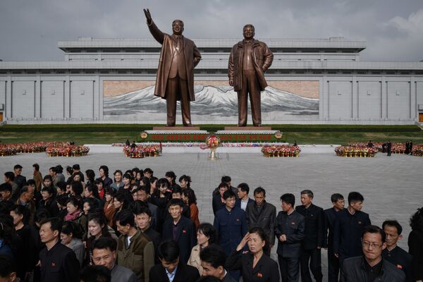 Жители после дани памяти у статуй лидеров КНДР Ким Ир Сена и Ким Чен Ира в Пхеньяне - Sputnik Абхазия