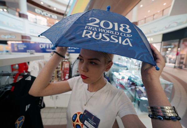 Девушка с зонтиком в официальном магазине в Калининграде по продаже сувениров и атрибутики к чемпионату мира по футболу 2018 в России - Sputnik Абхазия