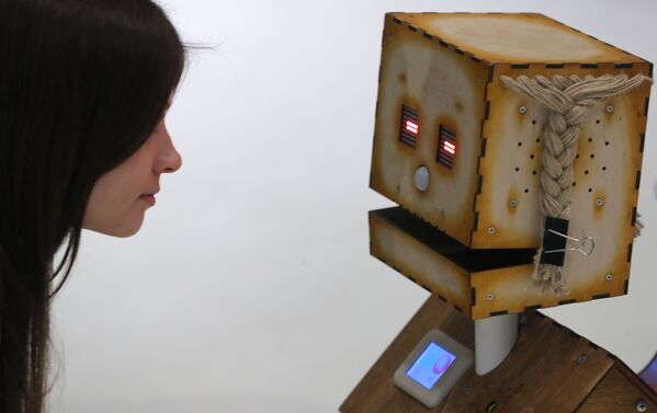 Посетительница рассматривает робота Деревяку компании Robodem на форуме-выставке Skolkovo Robotics в Москве - Sputnik Абхазия