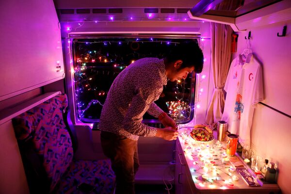 Молодой человек украшает свое купе Восточного экспресса свечами и гирляндами, Анкара - Карс, Турция - Sputnik Абхазия