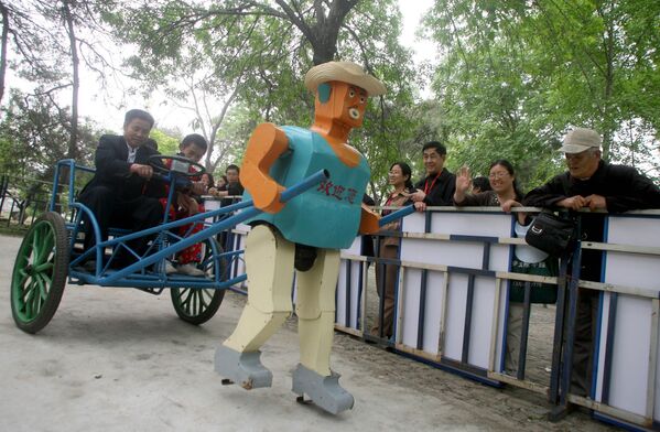 Китайский крестьянин в повозке, запряженной собранным им роботом, в парке Пекина - Sputnik Абхазия