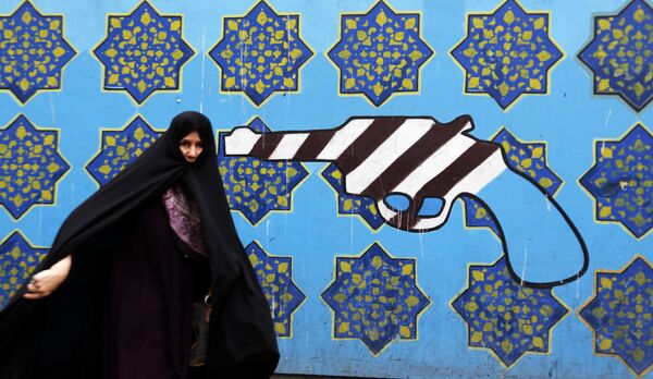Иранка на фоне граффити у бывшего здания посольства США в Тегеране - Sputnik Абхазия