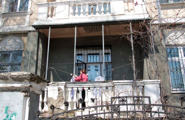 Центр города. Женщина развешивает белье на балконе старинной усадьбы - Sputnik Абхазия