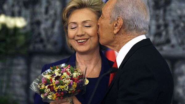Президент Израиля Шимон Перес целует госсекретаря США Хиллари Клинтон, преподнося ей букет в конце совместной пресс-конференции после их встречи в Иерусалиме, 2009 год - Sputnik Абхазия