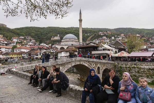 Люди сидят рядом с каменным мостом с видом на город Призрен, Косово - Sputnik Абхазия