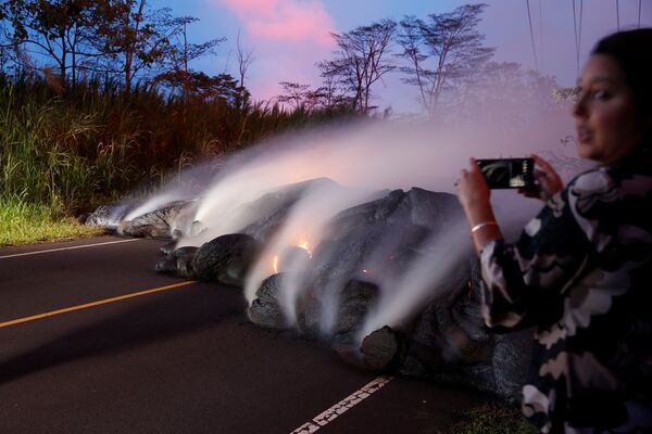 Журналист во время фотографирования лавы с вулкана Килауэа на Гавайях - Sputnik Абхазия
