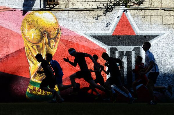 Игроки молодежного футбольного клуба во время разминки на футбольной площадке в Петроградском районе Санкт-Петербурга - Sputnik Абхазия