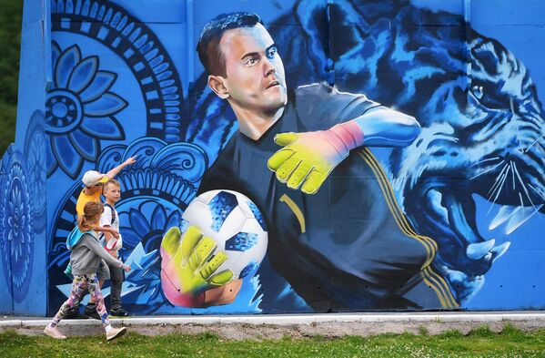 Дети рассматривают граффити с изображением вратаря сборной России по футболу Игоря Акинфеева в Щелково - Sputnik Абхазия