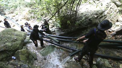 Тайские военнослужащие устанавливают трубы во время операции по спасению детей их пещеры