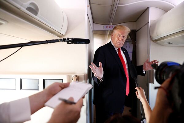 Президент США Дональд Трамп во время общения с журналистами на борту самолета - Sputnik Абхазия