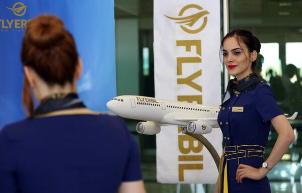 Стюардесса авиакомпании Fly Erbil позирует у модели самолета в международном аэропорту Erbil в Ираке - Sputnik Абхазия
