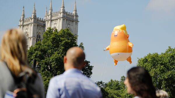 Люди проходят мимо воздушного шара с изображением президента США Дональда Трампа - Sputnik Абхазия