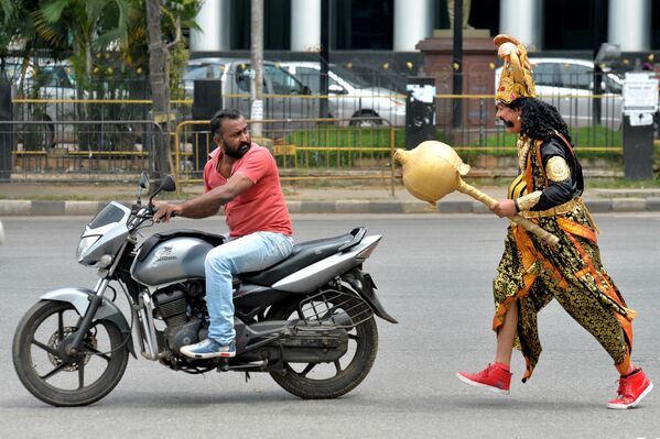 Человек в костюме бога смерти Ямы подходит к мотоциклисту во время акции Недели безопасности на дорогах в  Бангалоре, Индия - Sputnik Абхазия