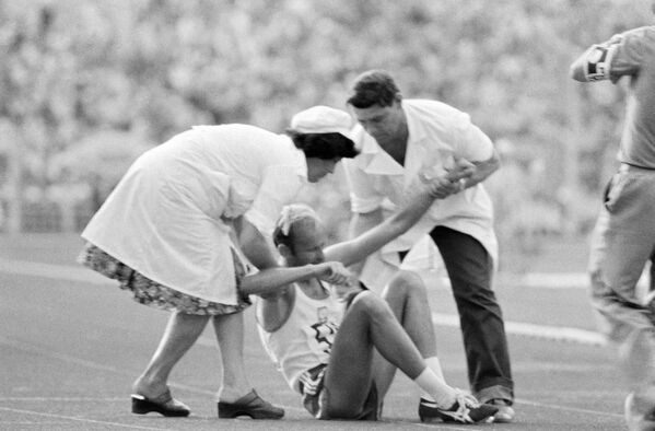 Врачи оказывают помощь легкоатлету, получившему травму во время соревнований. XXII летние Олимпийские игры в Москве, 1980 год - Sputnik Абхазия