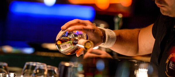 Бармен разливает напитки, стоя за барной стойкой в клубе Бармен разливает напитки, стоя за барной стойкой в клубе - Sputnik Абхазия