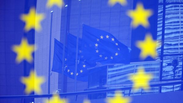Флаги Евросоюза в отражении на стенде с эмблемой ЕС - Sputnik Абхазия