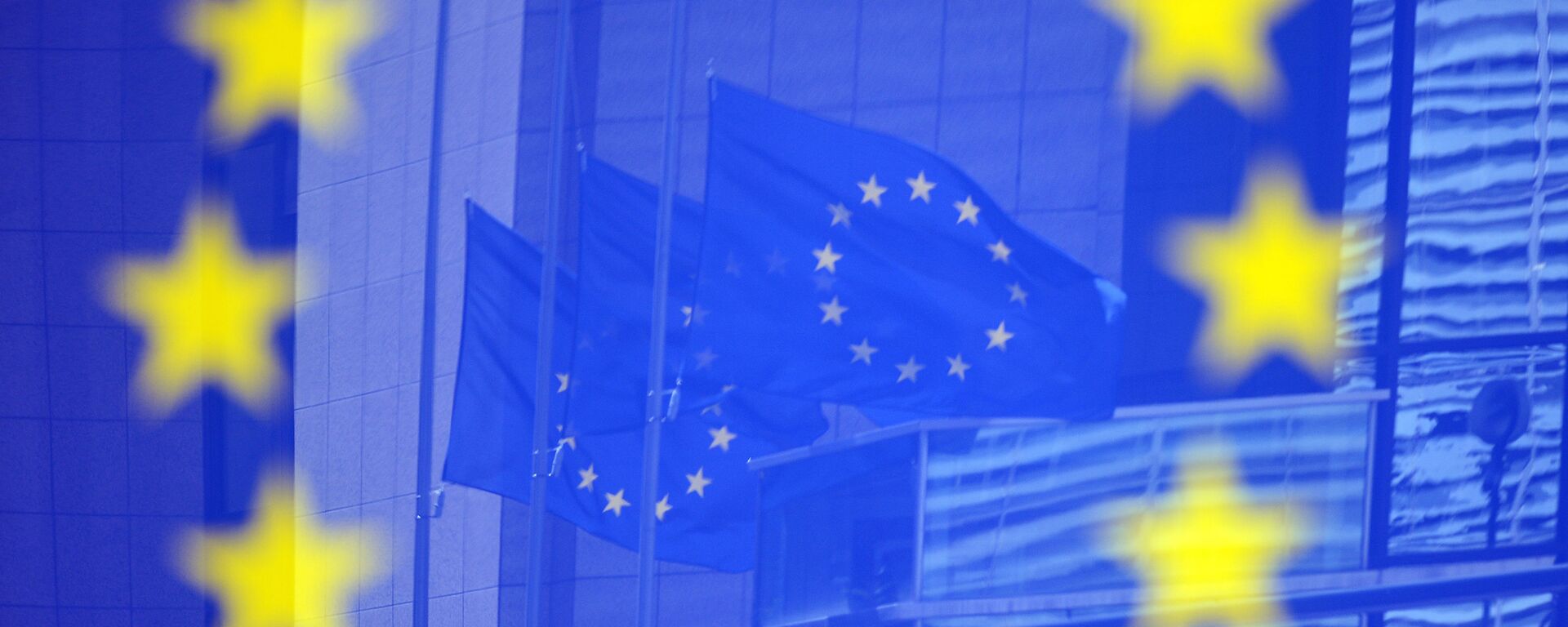 Флаги Евросоюза в отражении на стенде с эмблемой ЕС - Sputnik Абхазия, 1920, 10.04.2022