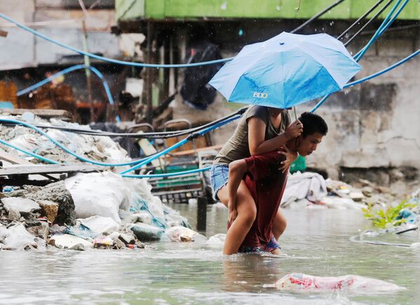 На улице филиппинского города Кесон, затопленной в результате муссонных ливней и тропического шторма Son-Tinh - Sputnik Абхазия