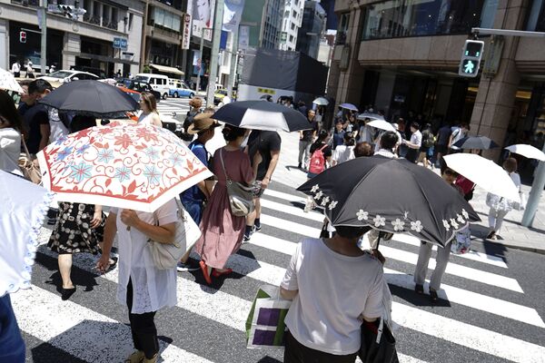 Прохожие с зонтами на улице во время аномальной жары в Токио - Sputnik Абхазия
