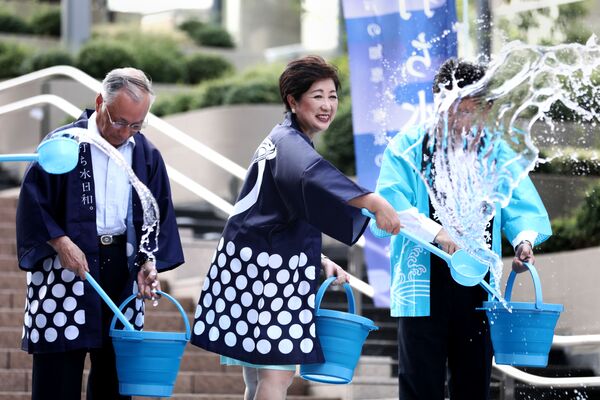 Губернатор Токио Юрико Коикэ выливает воду на землю во время акции по охлаждению Токио в дни аномальной жары - Sputnik Абхазия