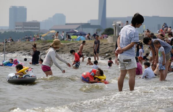 Люди с детьми купаются во время жары в парке Токио - Sputnik Абхазия
