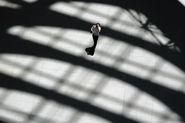 Мужчина идет в тени зданий во время аномальной жары в Токио - Sputnik Абхазия