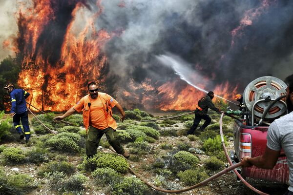 Пожарные и волонтеры пытаются тушить пламя во время лесных пожаров недалеко от Афин - Sputnik Абхазия