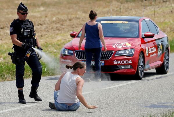 Полицейский распыляет перцовый спрей в лицо протестующей женщине во время велогонки Тур де Франс - Sputnik Абхазия