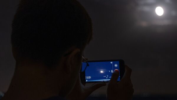 Мужчина снимает на телефон луну во время полного затмения из обсерватории Кубанского Государственного университета - Sputnik Абхазия