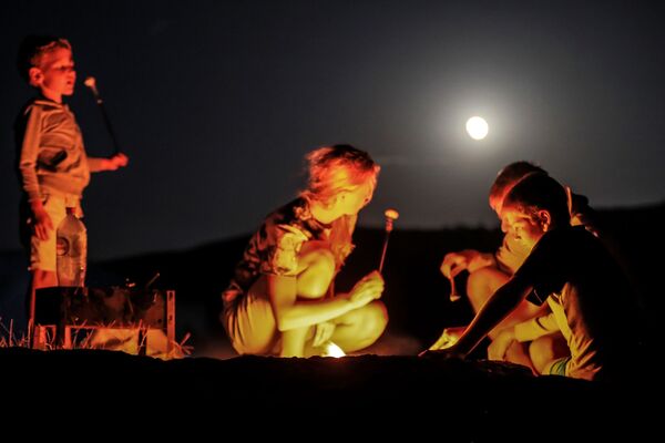 Туристы во время полного лунного затмения над мысом Меганом в Крыму - Sputnik Абхазия