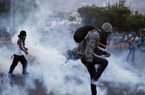 Протестующие против поднятия цен на общественный транспорт и бензин во время столкновения с полицией в Тегусигальпе, Гондурас - Sputnik Абхазия