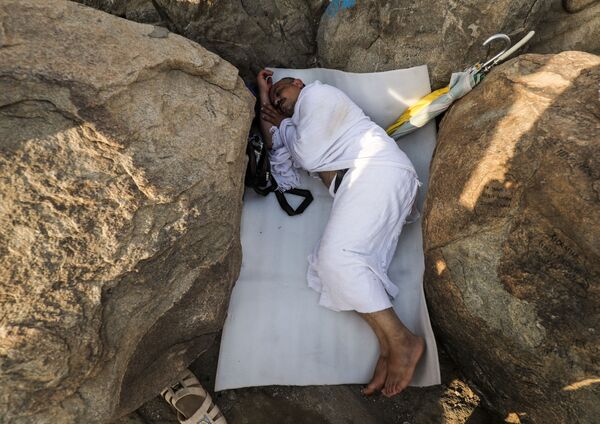 Мусульманский паломник спит между скалами горы Арафат близ Мекки во время хаджа, Саудвоская Аравия - Sputnik Абхазия