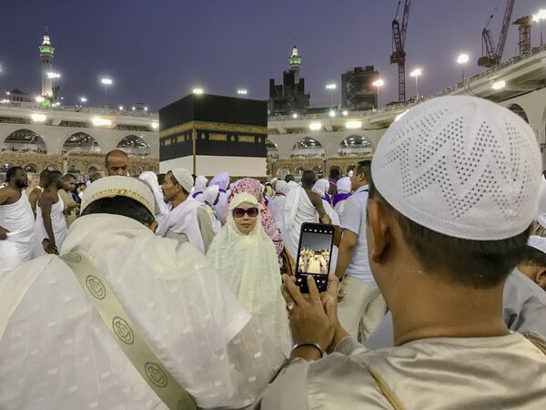 Мусульманские паломники фотографируются перед Каабой в мечети аль-Харам в Мекке, Саудовская Аравия - Sputnik Абхазия
