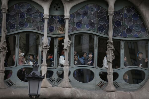 Туристы выглядывают из окна здания Каса-Батльо архитектора Антонио Гауди в Барселоне, Испания - Sputnik Абхазия