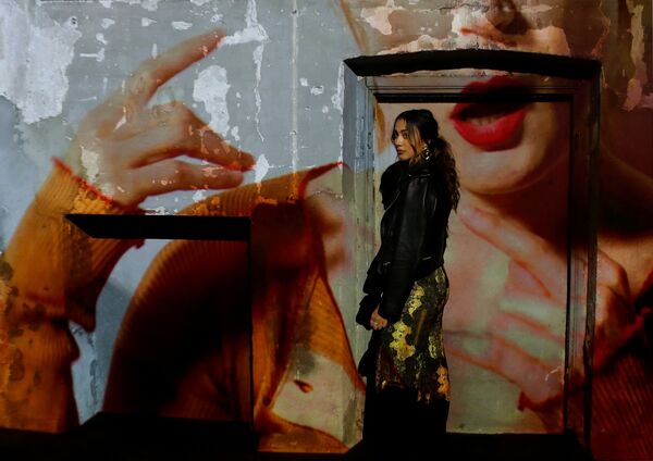 Гостья напротив видеопроекции во время показа мод на Неделе моды Весна/Лето 2019 в Милане - Sputnik Абхазия