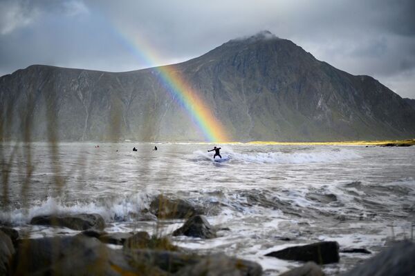 Серфер на фоне радуги в водах коммуны Флакстад на севере Норвегии - Sputnik Абхазия