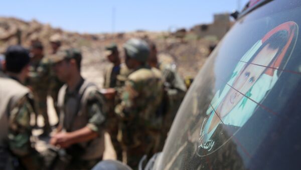 Сирийские военные рядом с наклейкой, представляющей президента Сирии Башара Асада - Sputnik Абхазия