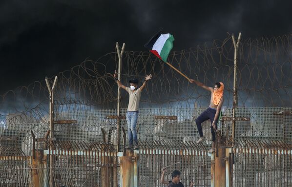 Протестующие палестинцы на металлическом заграждении у прибрежной границы между Израилем и Сектором Газа - Sputnik Абхазия