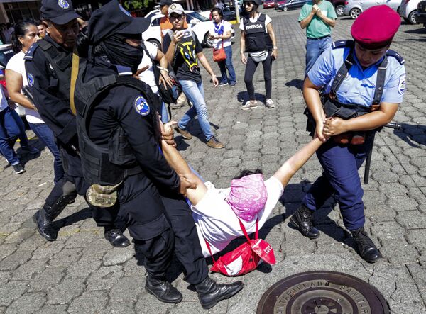 Никарагуанские полицейских из отряда по борьбе с уличными беспорядками уводят арестованную женщину во время протеста против правительства президента Даниэля Ортеги в Манагуа - Sputnik Абхазия