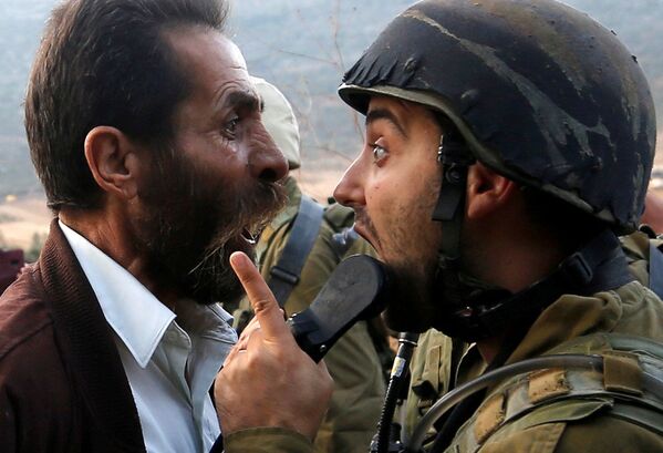 Палестинский мужчина спорит с израильским солдатом во время столкновений возле Наблуса на Западном берегу реки Иордан - Sputnik Абхазия