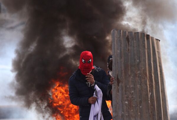 Кашмирцы на фоне горящих шин во время столкновений с полицией в Сринагаре - Sputnik Абхазия