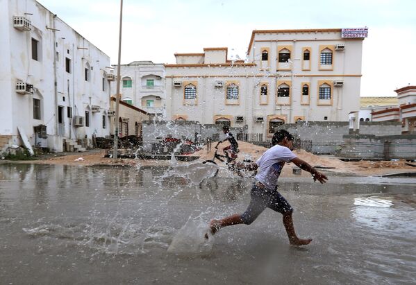 Дети играют на затопленной тропическим циклоном Любан улице в оманском городе Салала - Sputnik Абхазия