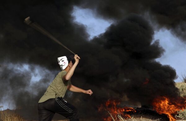 Протестующий бросает камень в израильские войска на границе Сектора Газа с Израилем - Sputnik Абхазия