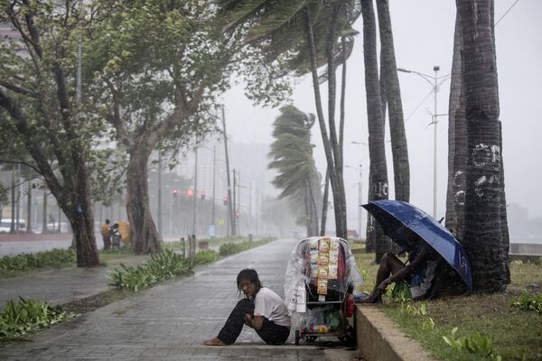 Уличный торговец во время тайфуна Юту на Филиппинах - Sputnik Абхазия