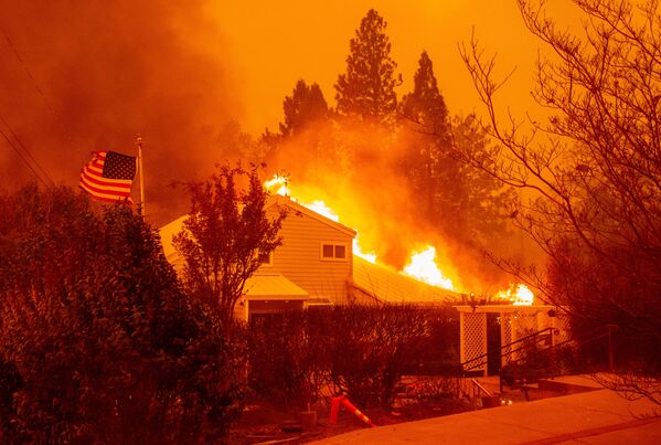 Охваченный огнем дом во время лесных пожаров в калифорнийском городе Парадайз - Sputnik Абхазия