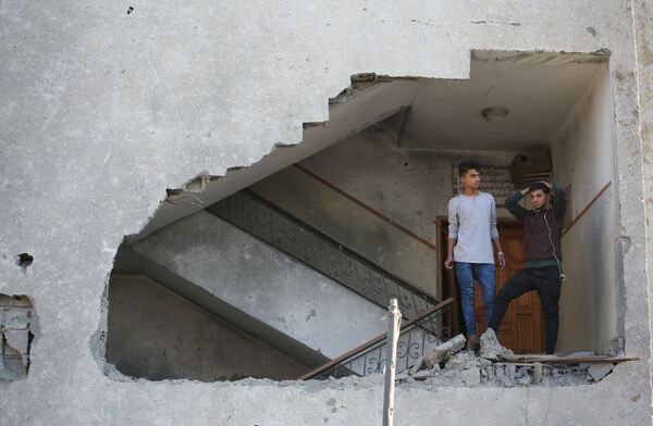 Молодые люди в жилом доме, пострадавшем от ракетного удара Израиля по территории сектора Газа - Sputnik Абхазия